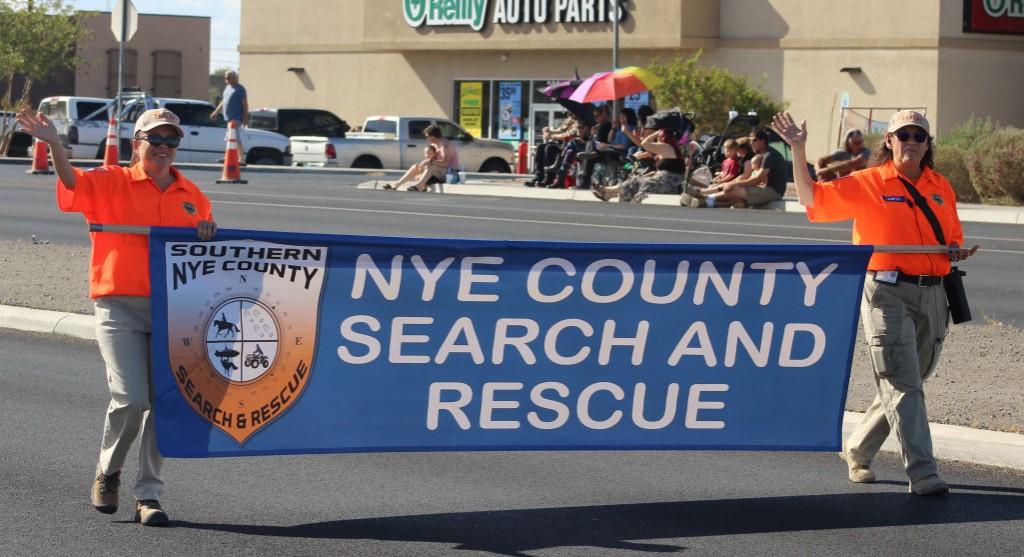 Pahrump Fall Festival Parade & Car Show - image of Nye County Search and Rescue banner carriers waving.