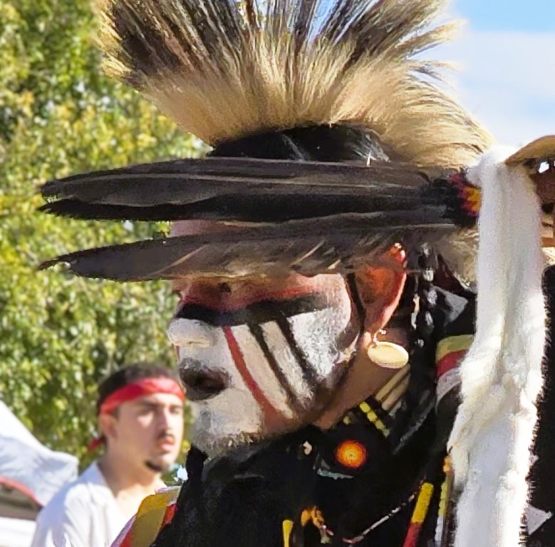 Pahrump Social Powwow - closeup image of of the Honorary Leader of the Grand Entrance displaying eagle feathers.
