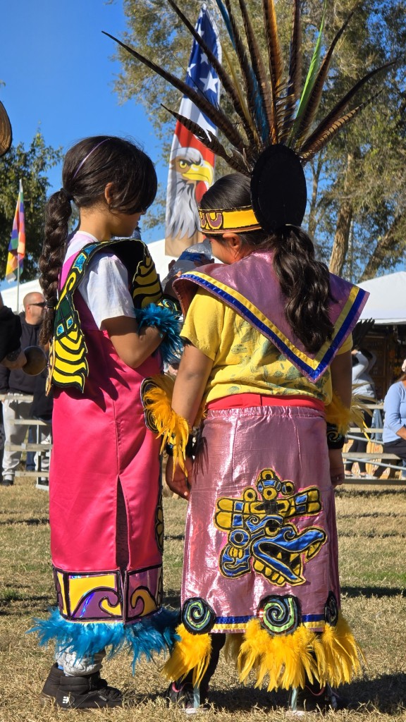 Pahrump Social Powwow 2025: An image of two children talking while under the watchful eye of the American Eagle.