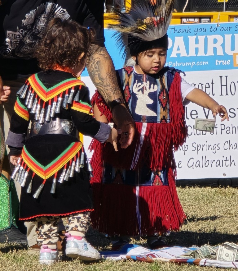 A delightful 4-year-old child awed by slow progress of falling dollar bill as seen in powwows: Cedar Band; Cedar City; Duck Valley; Elko; Ely; Fallon; Fort Mojave; Goshute; Las Vegas; Snow Mountain; Las Vegas Snow Mountain; Las Vegas Paiute Tribe; Las Vegas Snow Mountain Paiute; Las Vegas Snow Mountain Paiute Tribe; 33rd annual Las Vegas Snow Mountain Paiute; Moapa; Muckleshoot; Nevada Day; Numaga; Pahrump; Pahrump Valley; Pahrump Valley Social; Pahrump Social; Petrack; Petrack Park; Red Dress; Sacred Visions; San Marcos; San Marcos Apache; Stewart; Sycuan; UNLV; UNR; Univ. of Nev. Reno; and Walker River; & Western Navajo Fair.