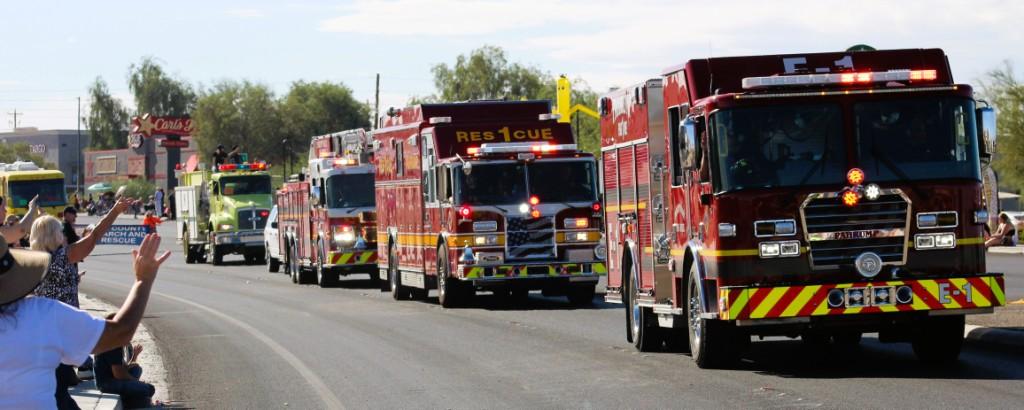 Pahrump Search & Rescue Units Pahrump Fall Festival Parade as audience waves at firemen.